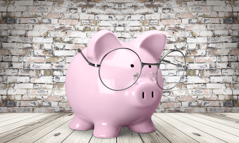 Picture: Pink piggy bank with spectacles on brick wall background, smart money saving concept